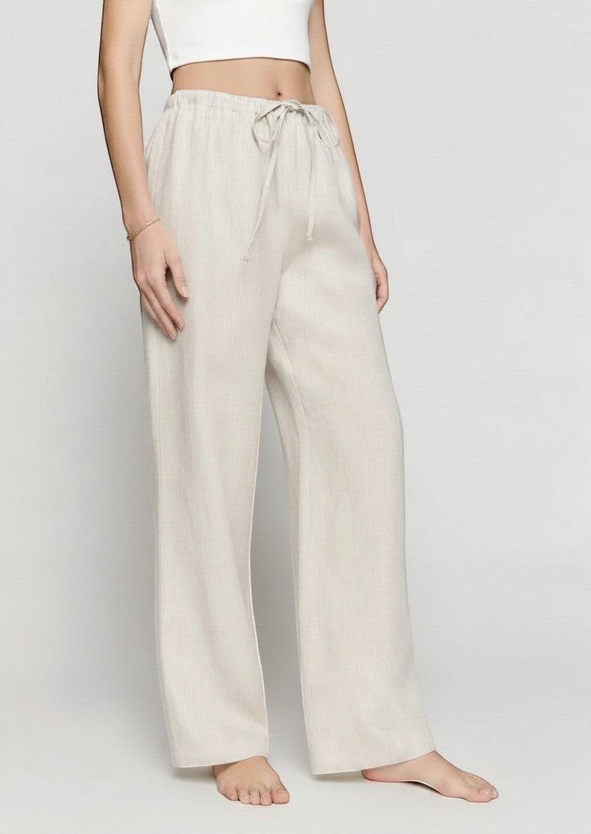 La Volta Reformation oatmeal linen pants with a relaxed leg and drawstring waist worn by a model