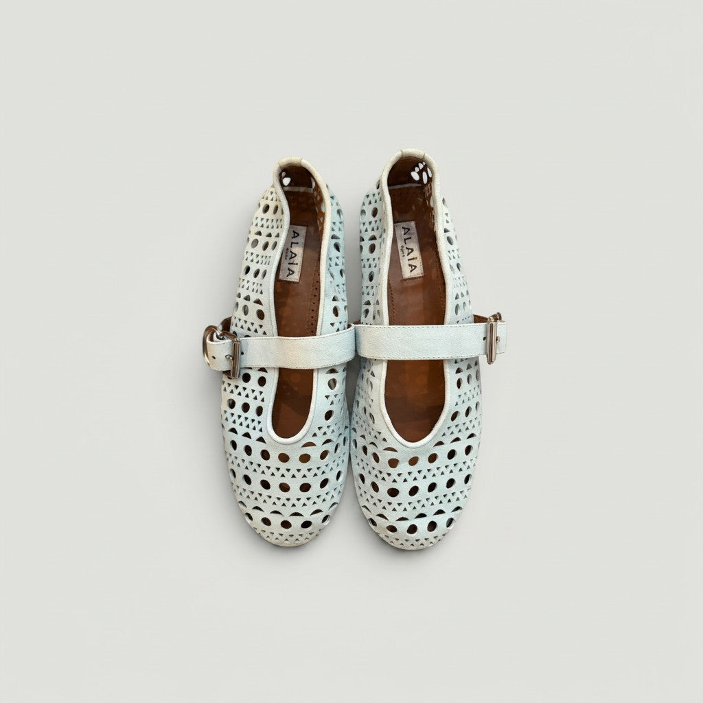 La Volta Alaïa light blue suede ballet flats featuring the signature Vienne laser-cut motif and buckle strap detail.